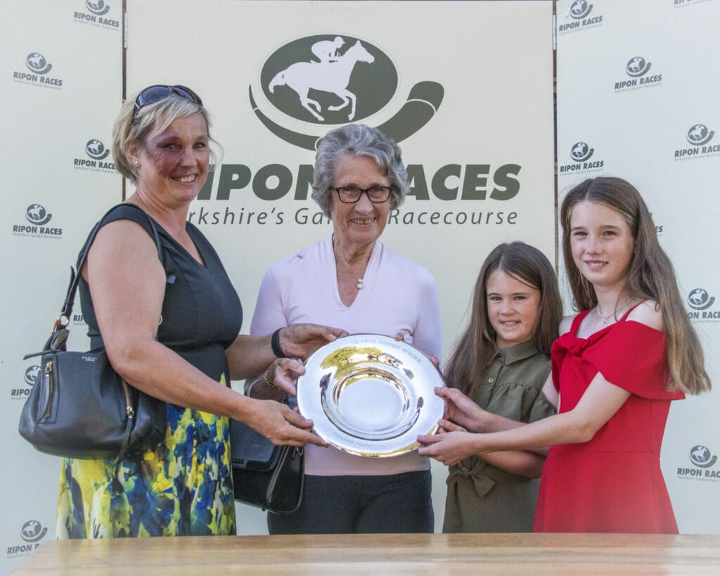 Grandma and great grandaughters present the trophy to Ruth